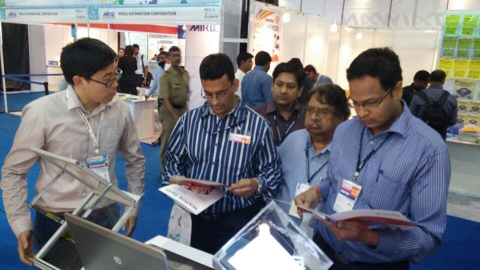Visitors reading product brochures at the Q-Tech booth